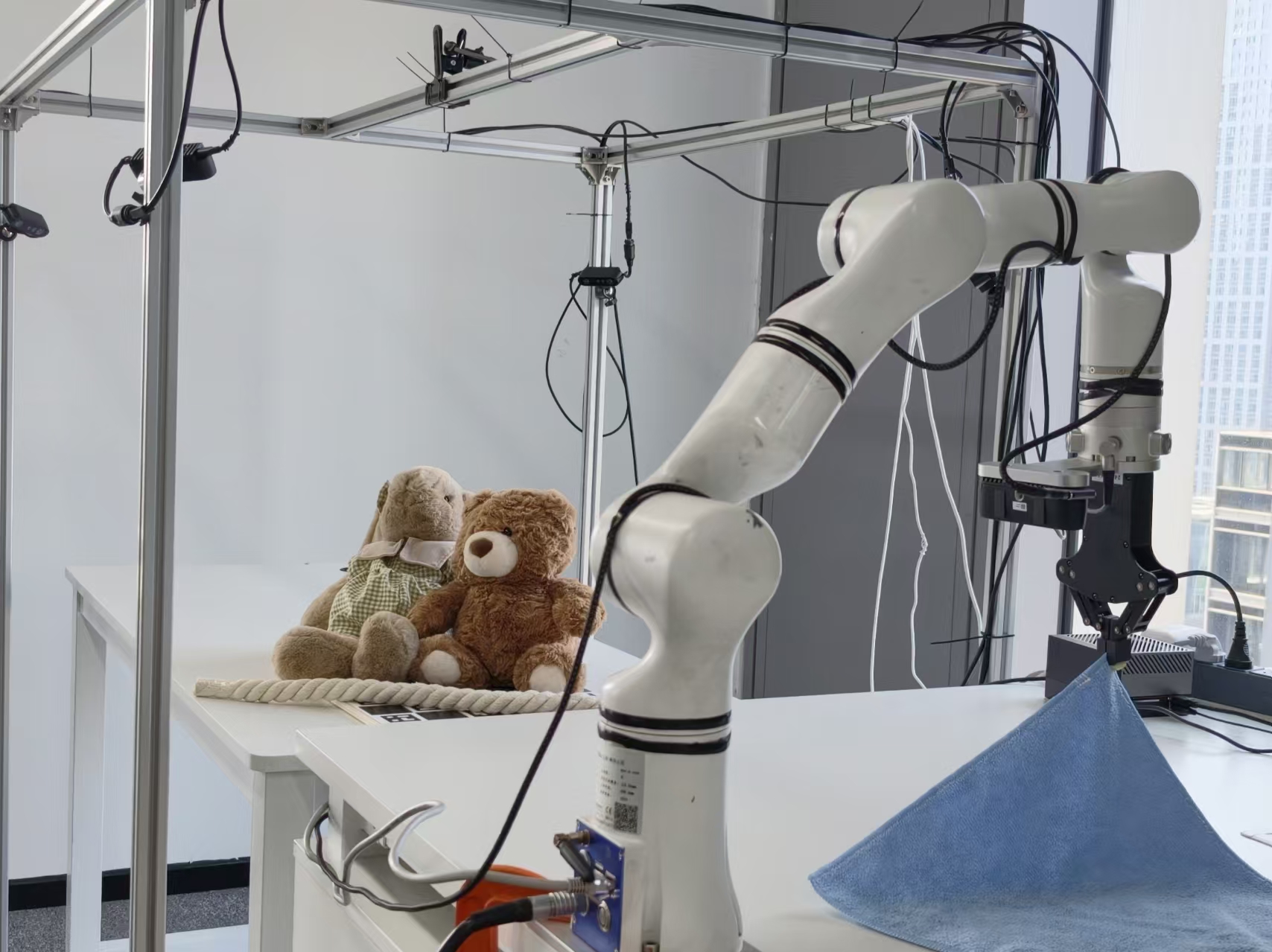 Robot manipulator lifting a cloth in the multi-camera setup